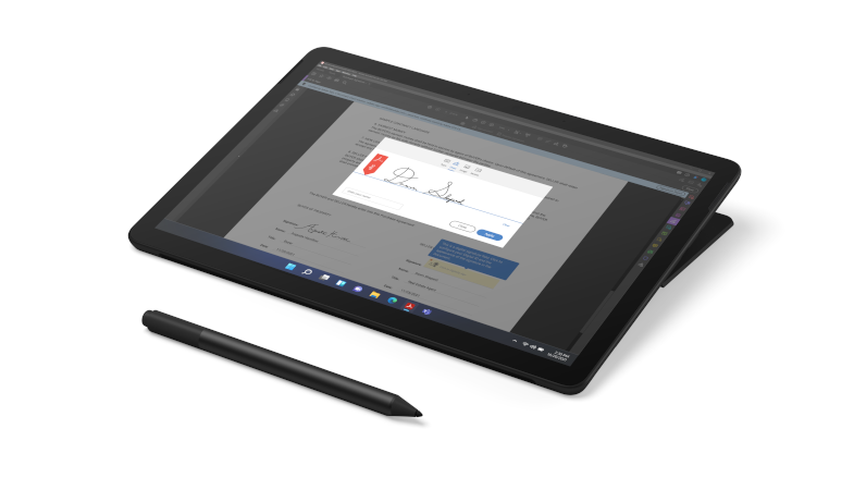 Surface Go 3 i matsort i studiotilstand med en Surface Pen i sort placeret foran den set fra oven