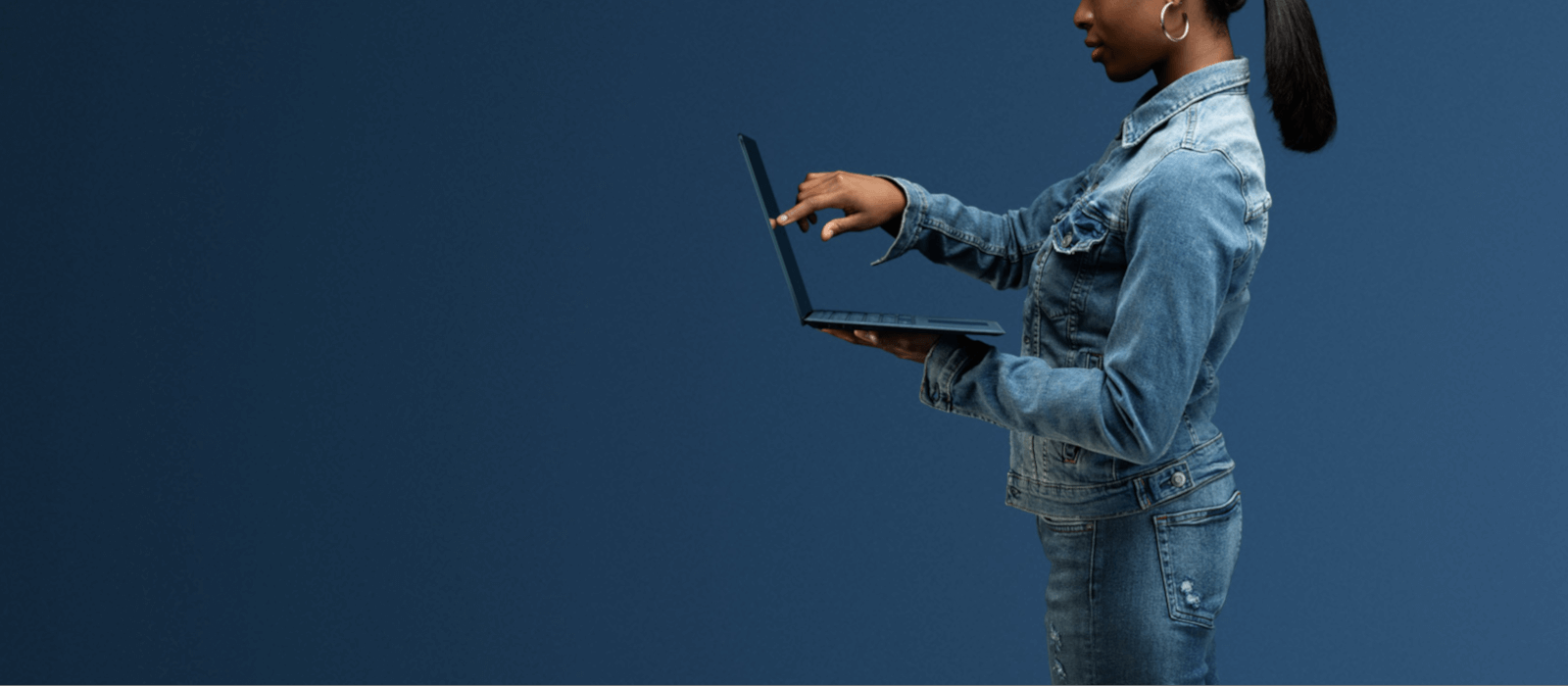 A woman is touching the display of the cobalt-blue Surface Laptop 