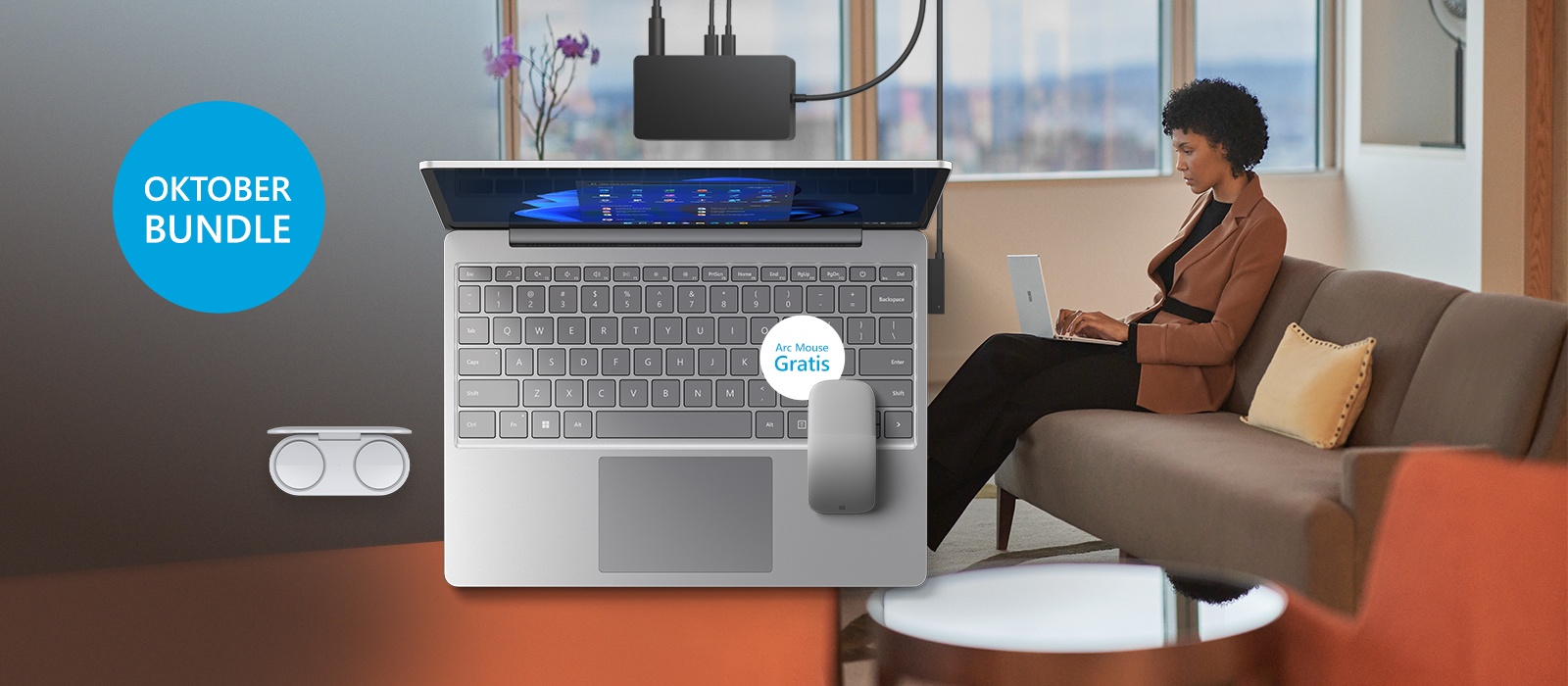 Surface Laptop Go 2 inklusive Surface Earbuds, Suface Dock 2 und Surface Arc Mouse sind vor einem Farbigen Hintergrund platziert auf welchem eine Frau den Surface Laptop Go 2 nutzt.