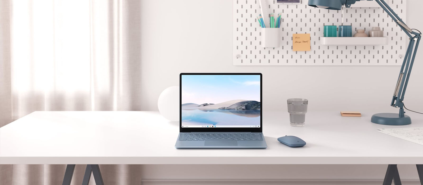 Der Surface Laptop Go 2 in Eisblau steht auf einem Schreibtisch 