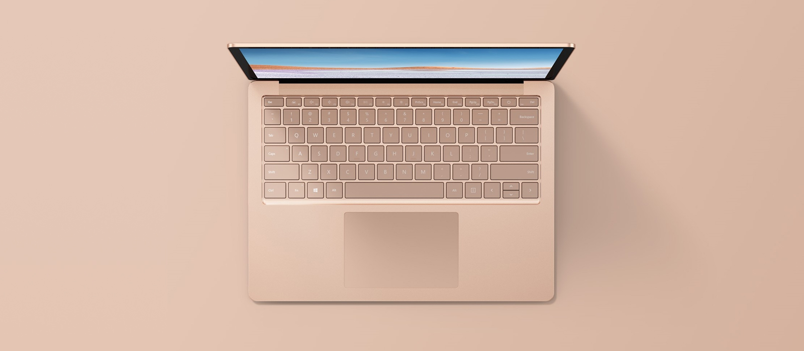 En sandstenfarvet Surface Laptop fra fugleperspektiv
