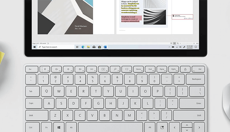 The Microsoft Designer Compact Keyboard in Glacier is positioned underneath a Surface Pro