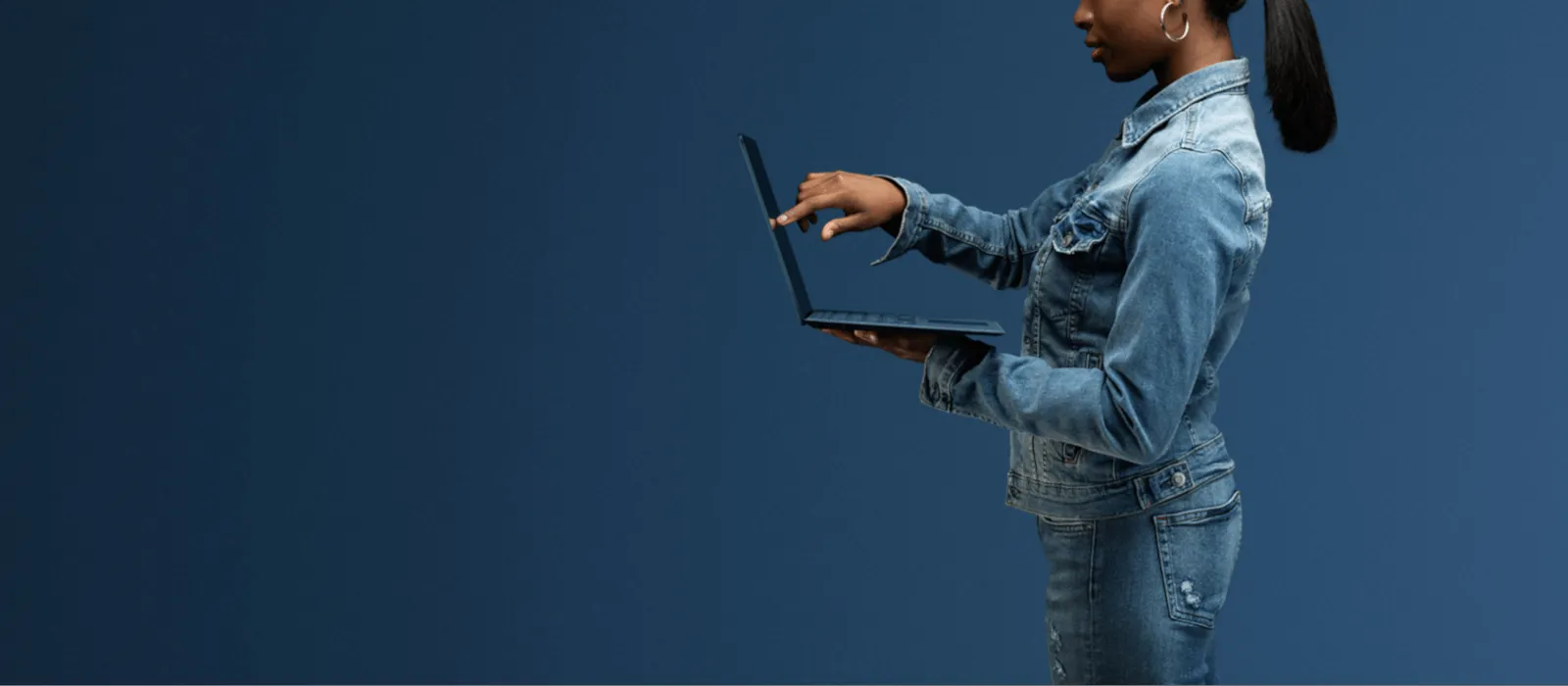 A woman is touching the display of the cobalt-blue Surface Laptop 