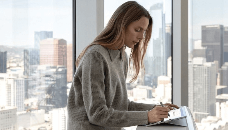 Une femme tape avec le Stylet Surface sur l'écran du Surface Pro
