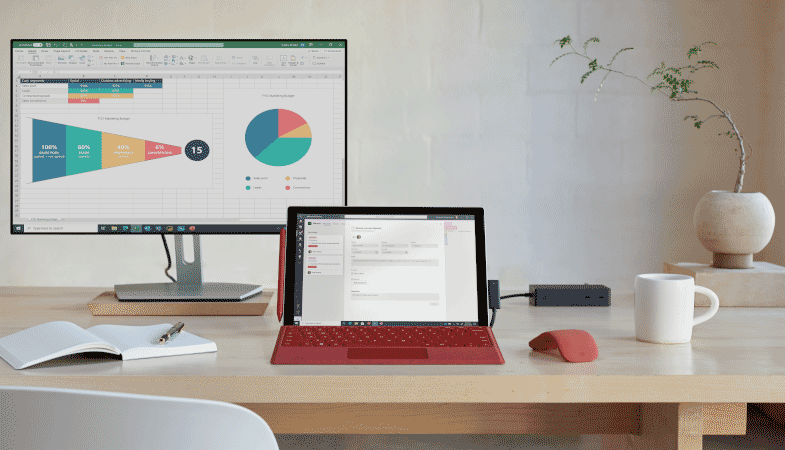 Ein Surface Pro 7 Plus steht auf einem Schreibtisch und ist per Surface Dock mit einem externen Monitor verbunden 