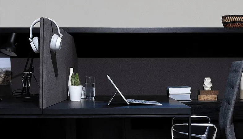 Seitliche Perspektive auf einen Schreibtisch, auf dem ein Surface Pro steht