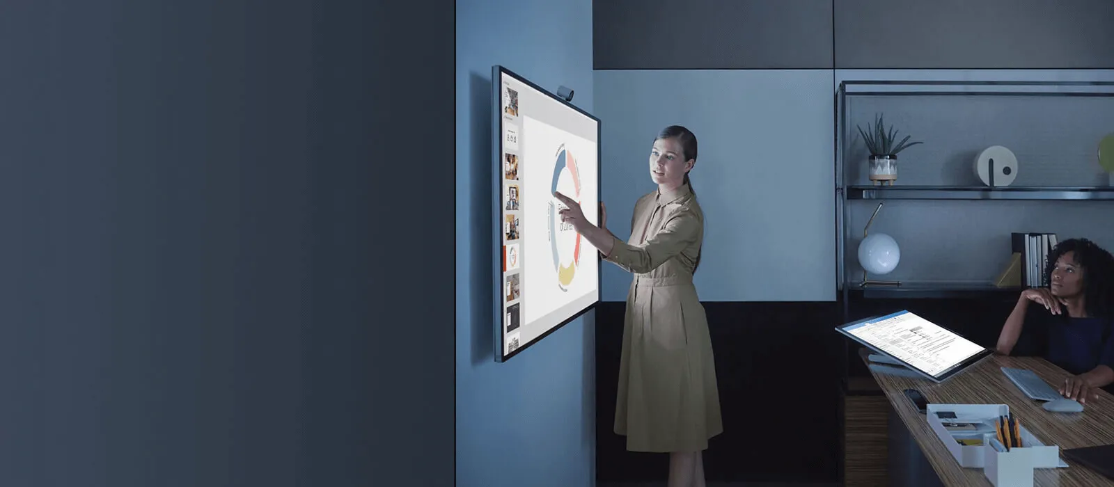 One women is presenting something to another women on the Surface Hub 3