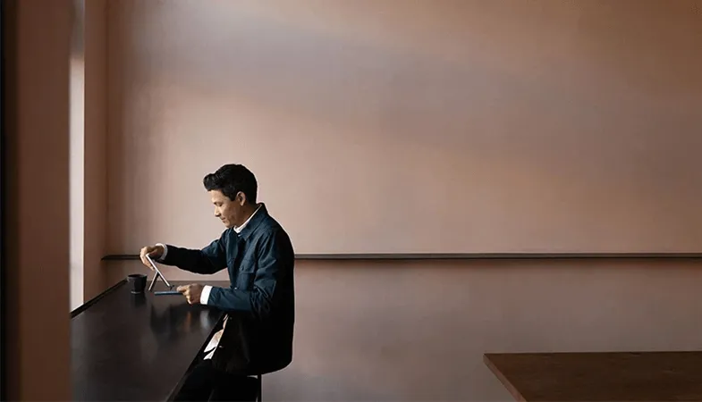 Highest security standards for sensitive company data with Microsoft 365 A man sitting in an empty room working on a Surface Go