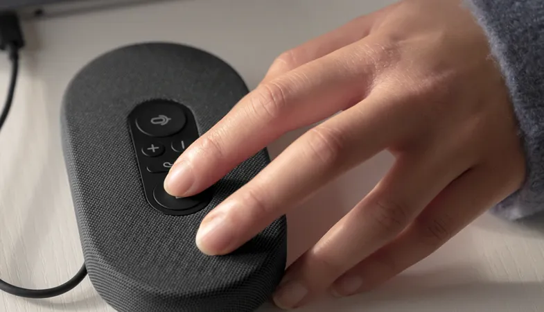 A person is using the buttons of the Microsoft Modern USB-C speaker