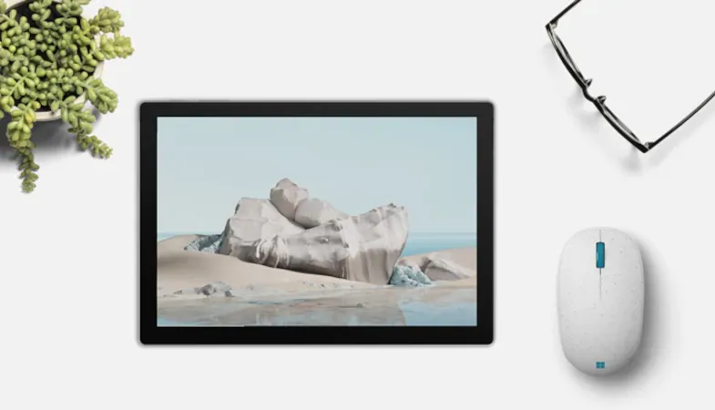 Die Microsoft Ocean Plastic Mouse ist neben einem Surface Pro auf einem Tisch platziert 