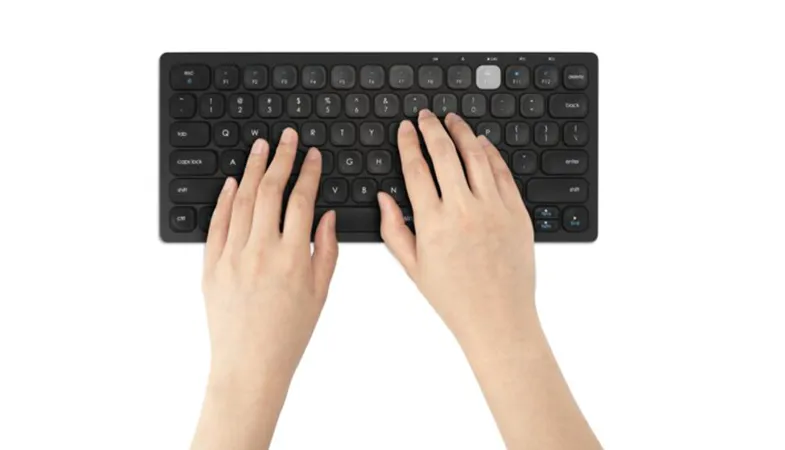 Person typing on Multi-Device Dual Wireless Compact Keyboard