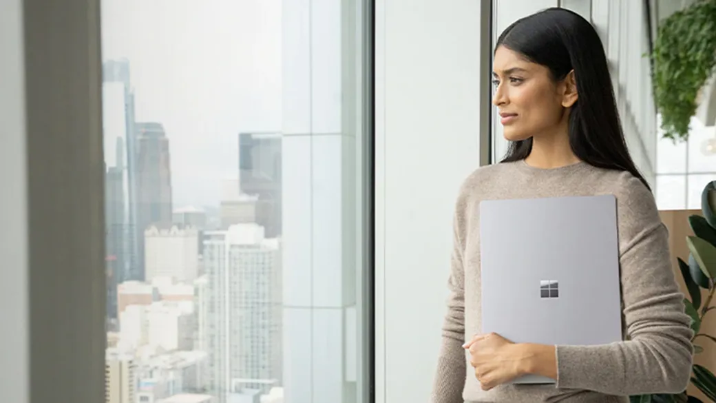 Eine Frau hält einen Surface Laptop 5 in der Hand