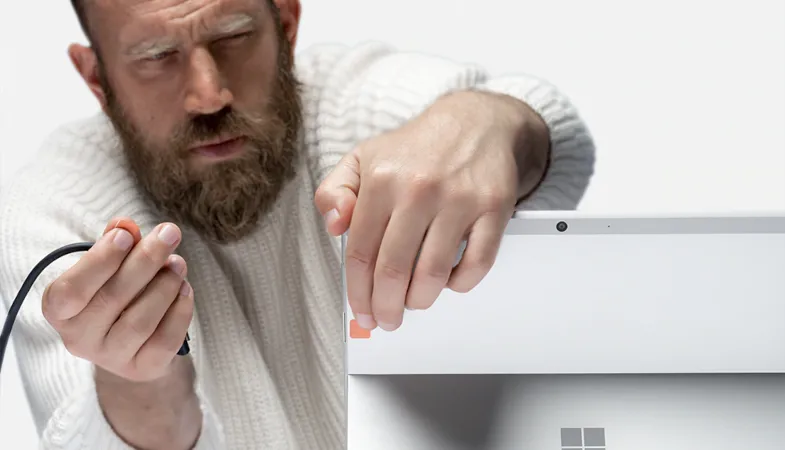 Eine Person bringt Anschlussbeschriftungen an ein Surface Pro an