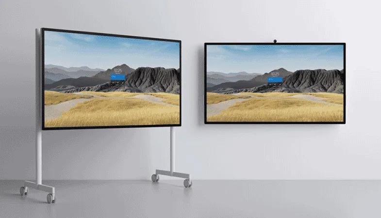 Two Surface Hub 2S as 85-inch models, one stands on a rolling stand, the other is hanging on the wall