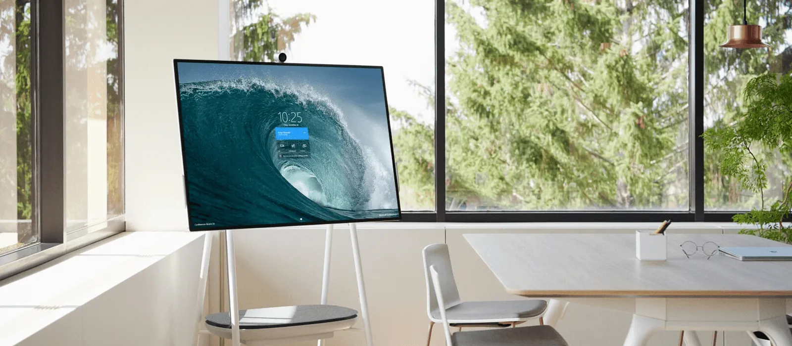 The Surface Hub 2 is standing in the corner of an office space