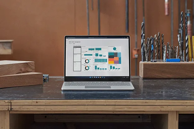 Vorderansicht auf einen platinfarbenen Surface Laptop Go 3 der auf einem Schreibtisch steht