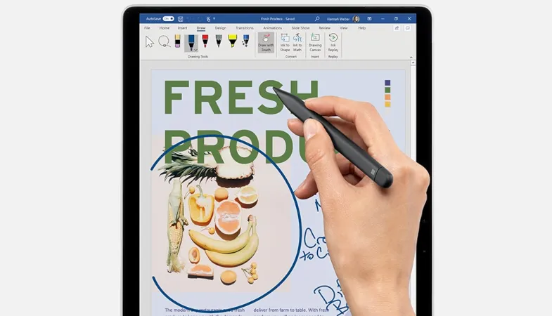 Surface Slim Pen 2 improved design  A person is working in a graphical Word document on a Surface with the Surface Slim Pen 2