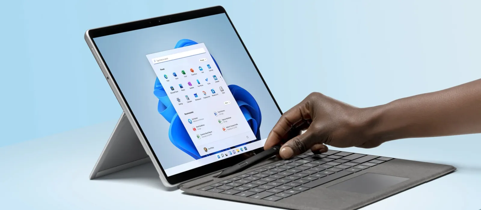Surface Pro Signature Keyboard with Slim Pen 2 offers an exceptional typing experience A person puts the Surface Slim Pen 2 into the charging box of the platinum-coloured Surface Pro Keyboard attached to a Surface Pro in laptop mode
