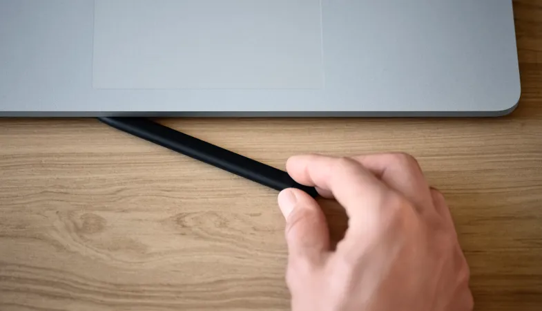 A person demonstrates the charging function of the Surface Laptop Studio for the Surface Slim Pen 2 