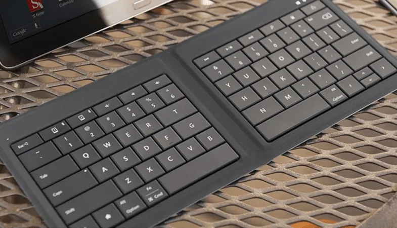 Microsoft Universal Foldable Keyboard kompakt fuer unterwegs  Das Microsoft Universal Foldable Keyboard liegt auf einem Tisch