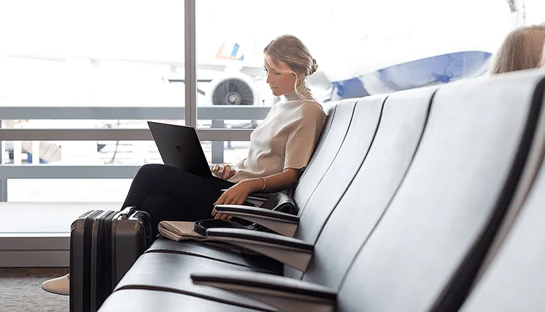 Fully installable Office applications on multiple devices with Microsoft 365 A woman sitting at the airport working on a Surface Laptop