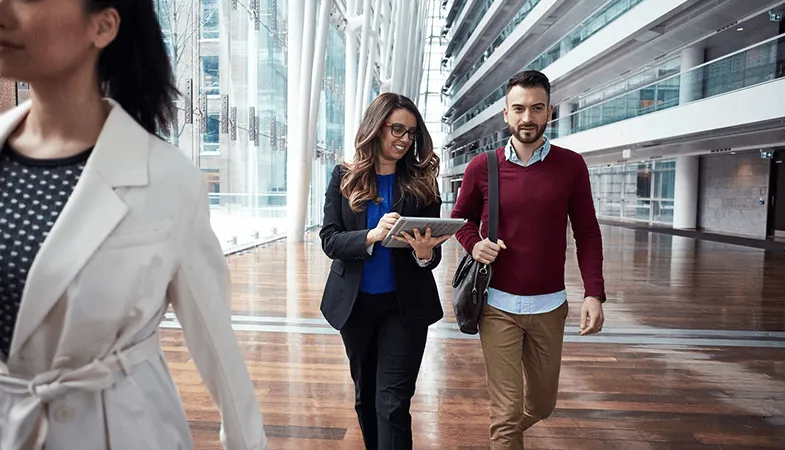 Colleagues walking down a hallway with a Microsoft Surface Pro