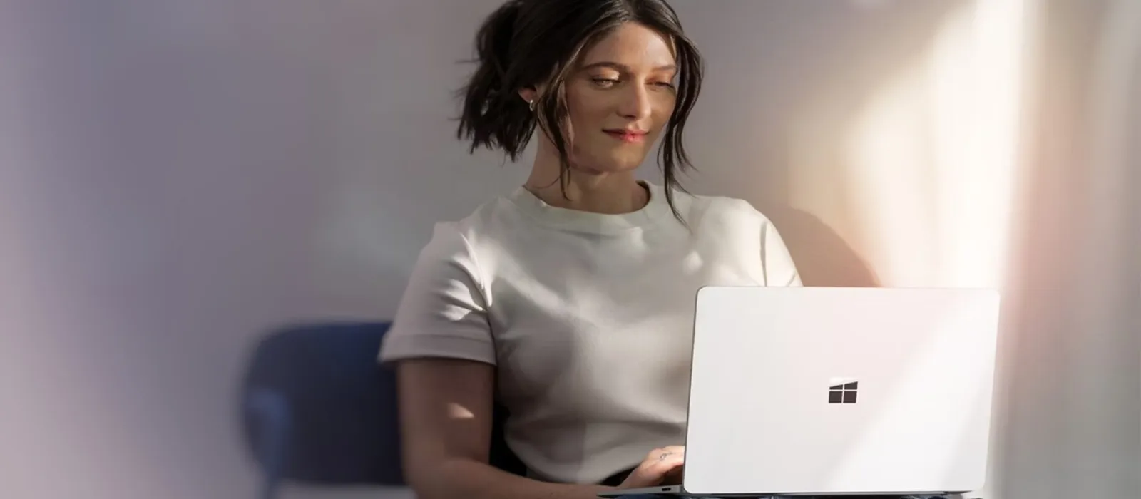 Eine Frau hält einen Surface Laptop auf den Beinen